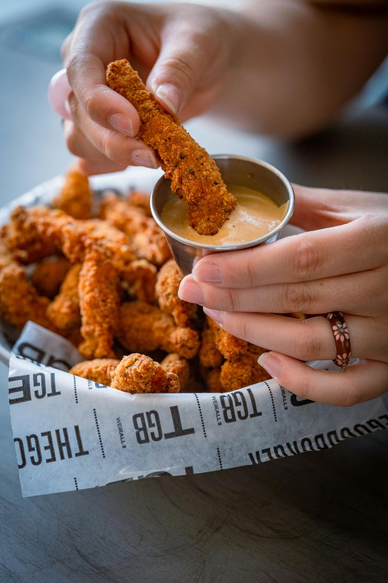 A Person Deeping Fried Meat in the Sauce
