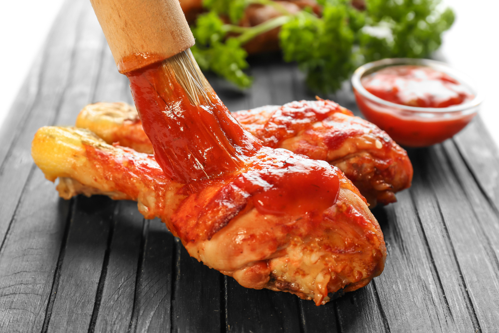 Spreading tasty tomato sauce on chicken legs