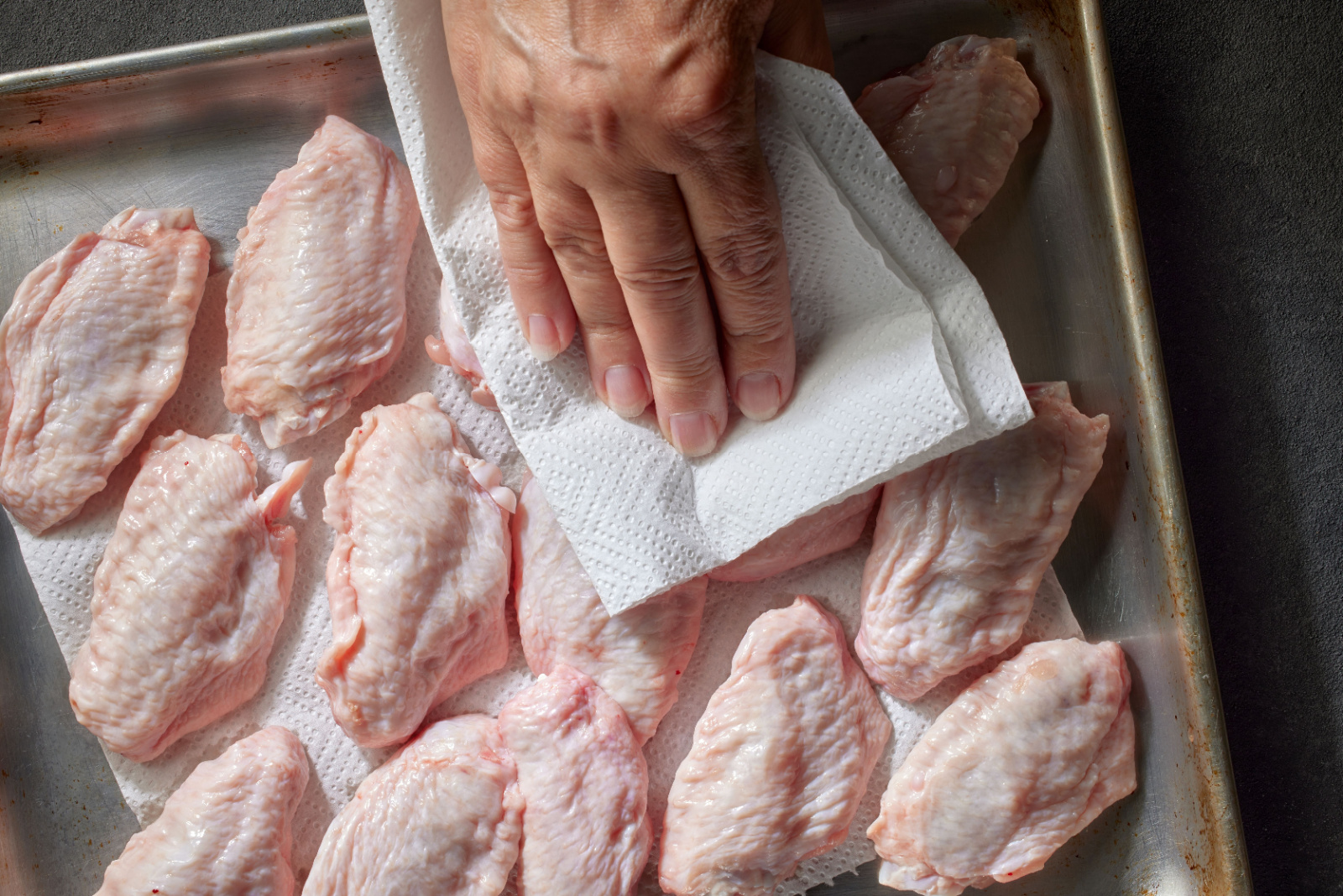 fresh raw chicken wings on grey kitchen table, top view. process of making crispy chicken wings