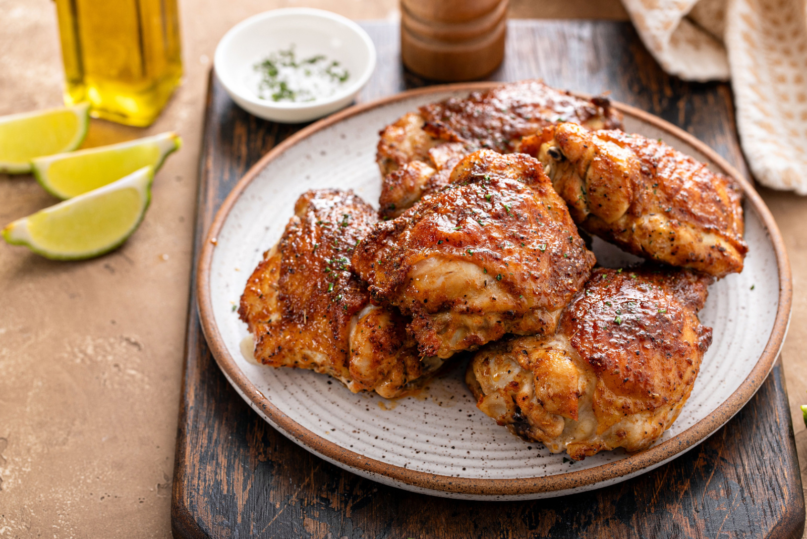 Chicken thighs roasted or air fried with paprika, spices rub and lime on a plate