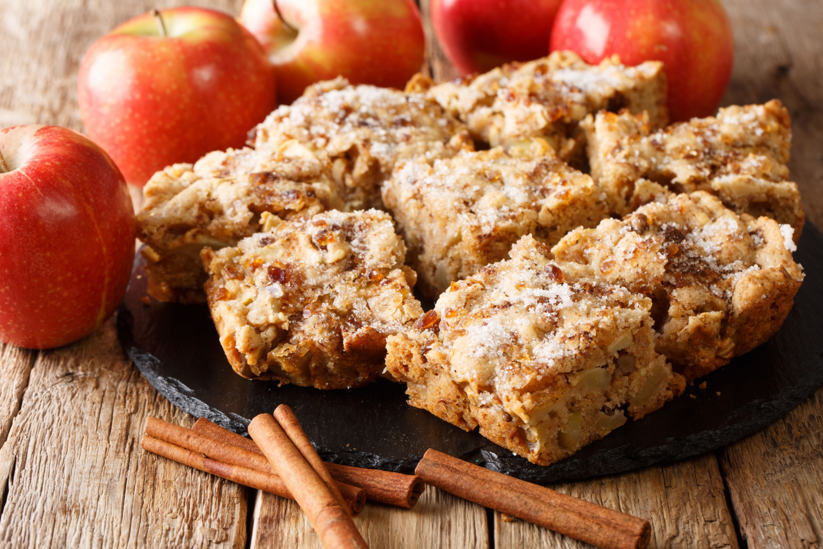 apple bars with cinnamon and nuts close-up on a slate board on the table. horizontal 