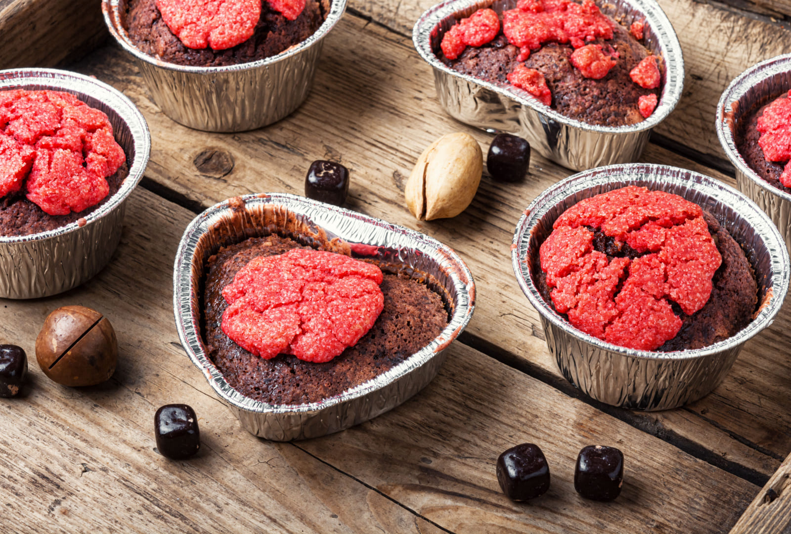 Homemade delicious muffins with nuts and chocolate on wooden background