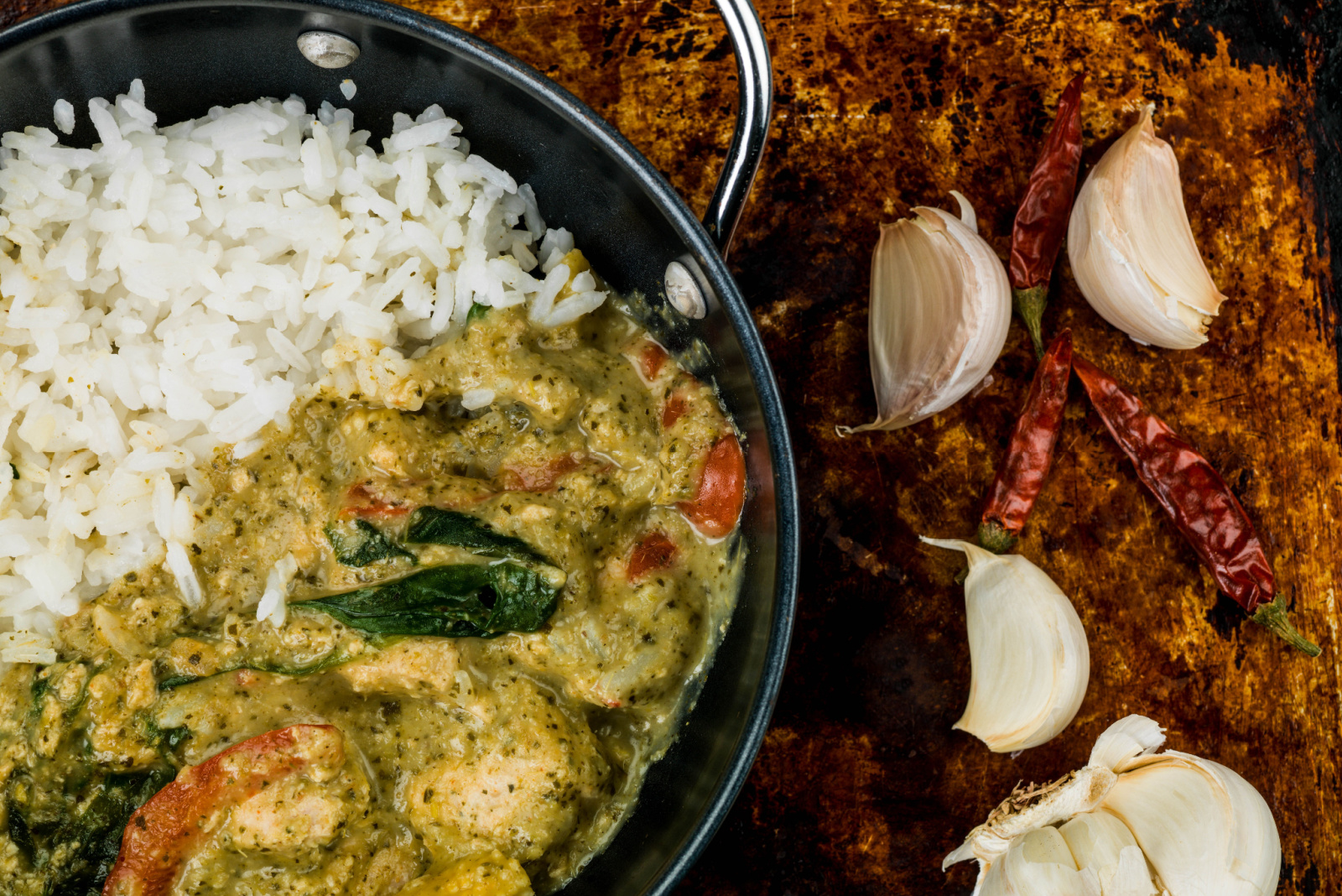 Thai Green Chicken Curry With Rice Against a Distressed Used Oven or Baking Tray