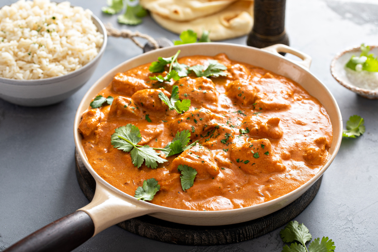 Chicken tikka masala, cooked marinated chicken chunks in spiced curry sauce, served with rice and naan bread