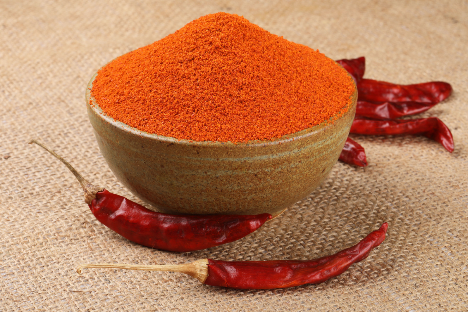 Indian spice Red chilli powder in white ceramic bowl .It is used as a spice (or spice blend) to add pungency (piquancy) and flavor to culinary dishes. 