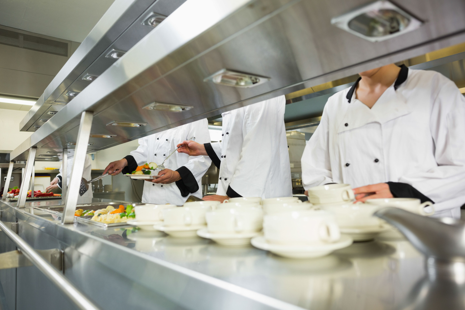 Four chefs working in a kitchen at the order station
