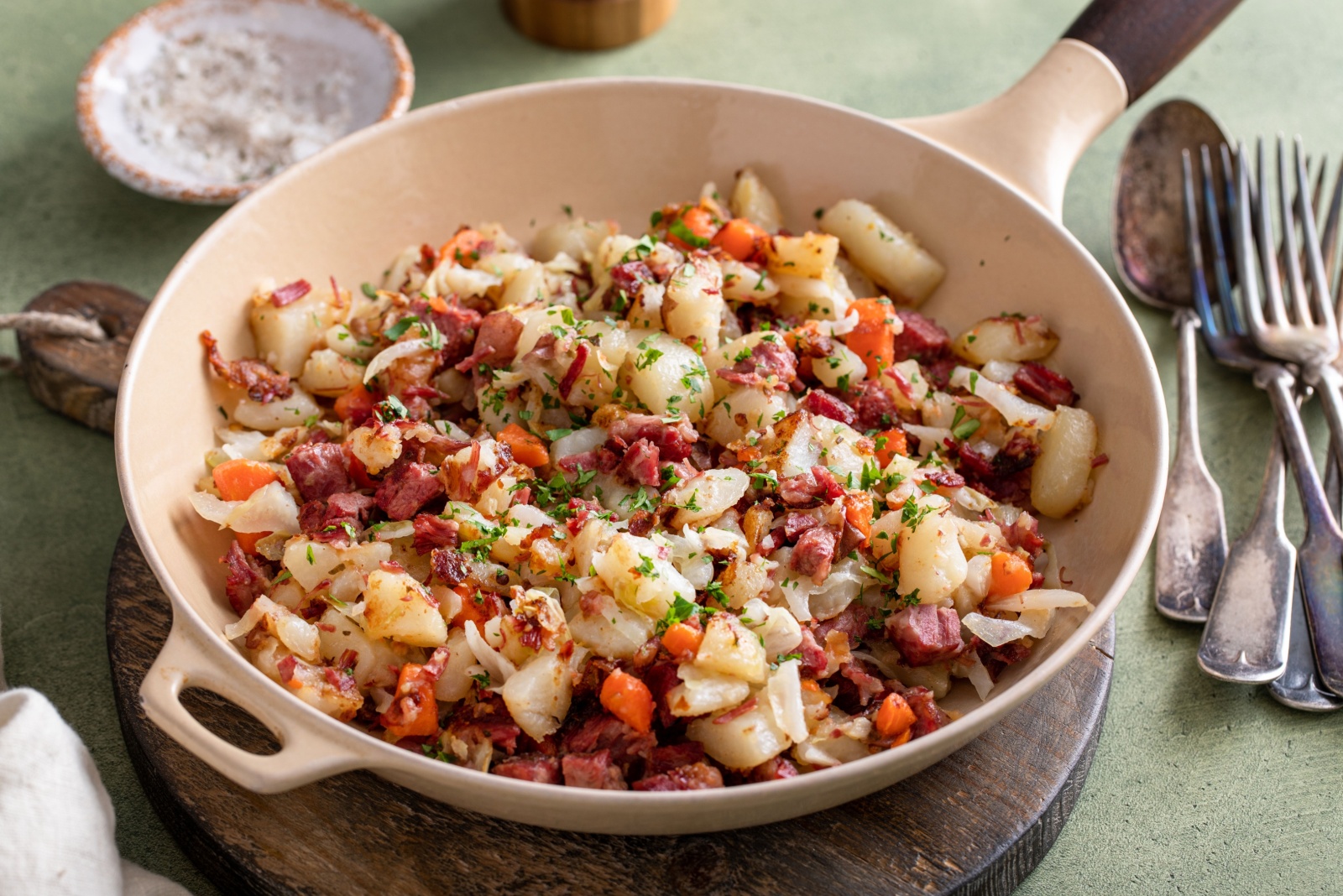 Corned beef hash with potatoes, cabbage and carrot in a cast iron pan