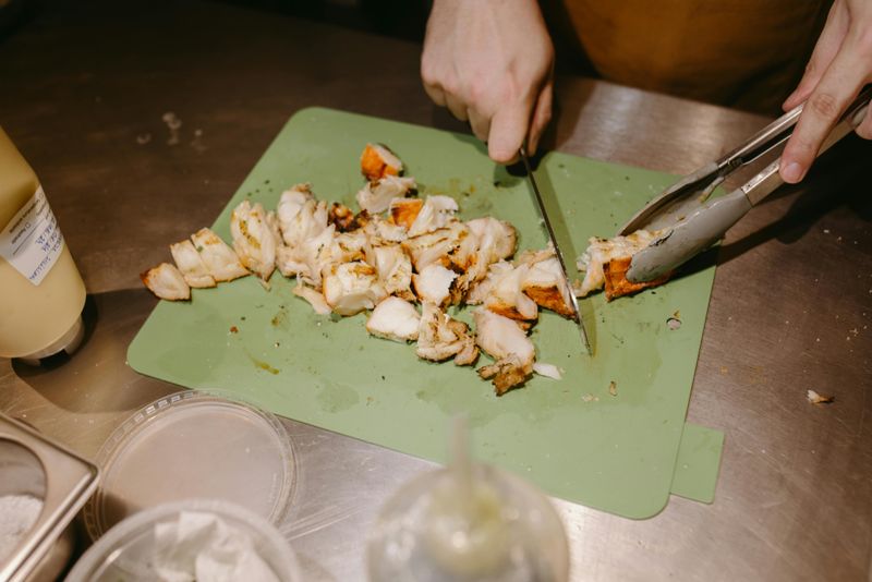 Person Hands Cutting Food on Tray