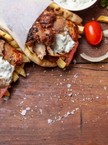 Gyro pita, shawarma, souvlaki. Traditional turkish, greek meat food. Two pita bread wraps and meat skewers on wooden table, banner