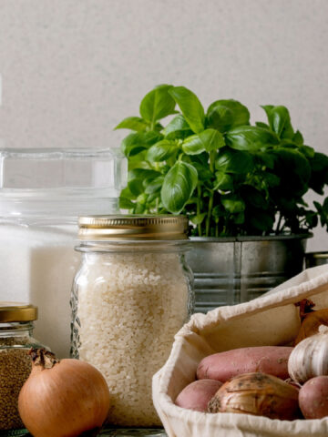 Food supplies crisis food stock for quarantine isolation period. Different glass jars with grains, pasta, cans of canned food, toilet paper, chalkboard handwritten chalk lettering Stay home and relax.