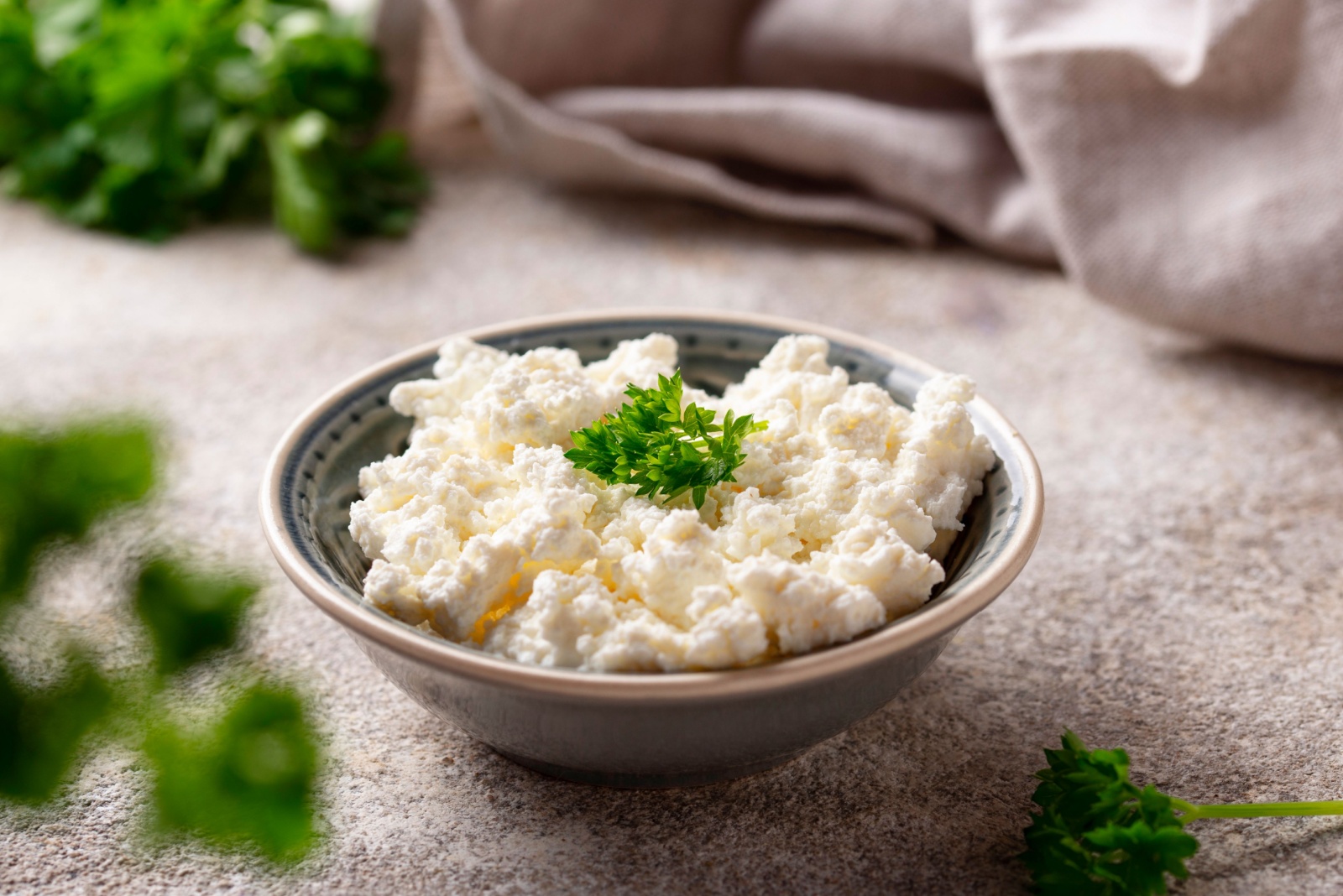 Bowl with homemade cottage cheese on light background