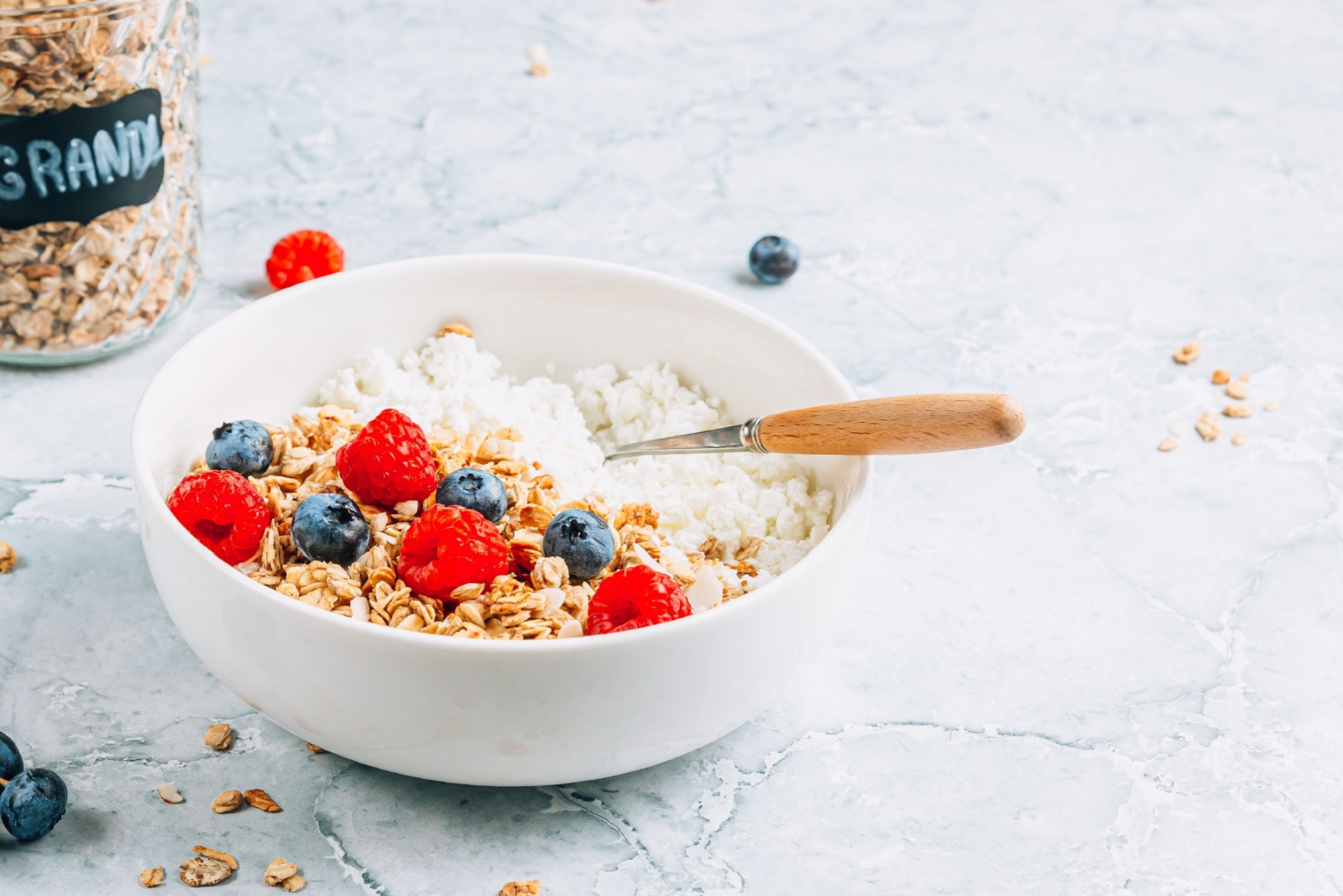 Cottage cheese breakfast bowl with granola, blueberry and raspberry.