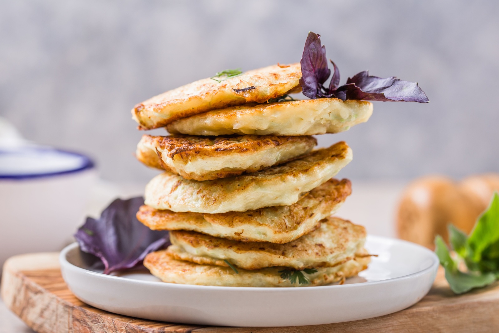 Vegetarian zucchini fritters or pancakes stack topped with sour cream and cilantro. Vegetable pancakes