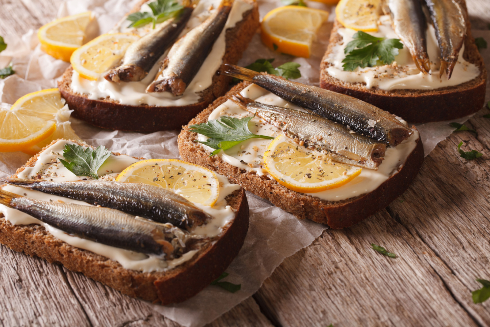 Tasty fish sandwiches with cream cheese and lemon close-up on the table. Horizontal 