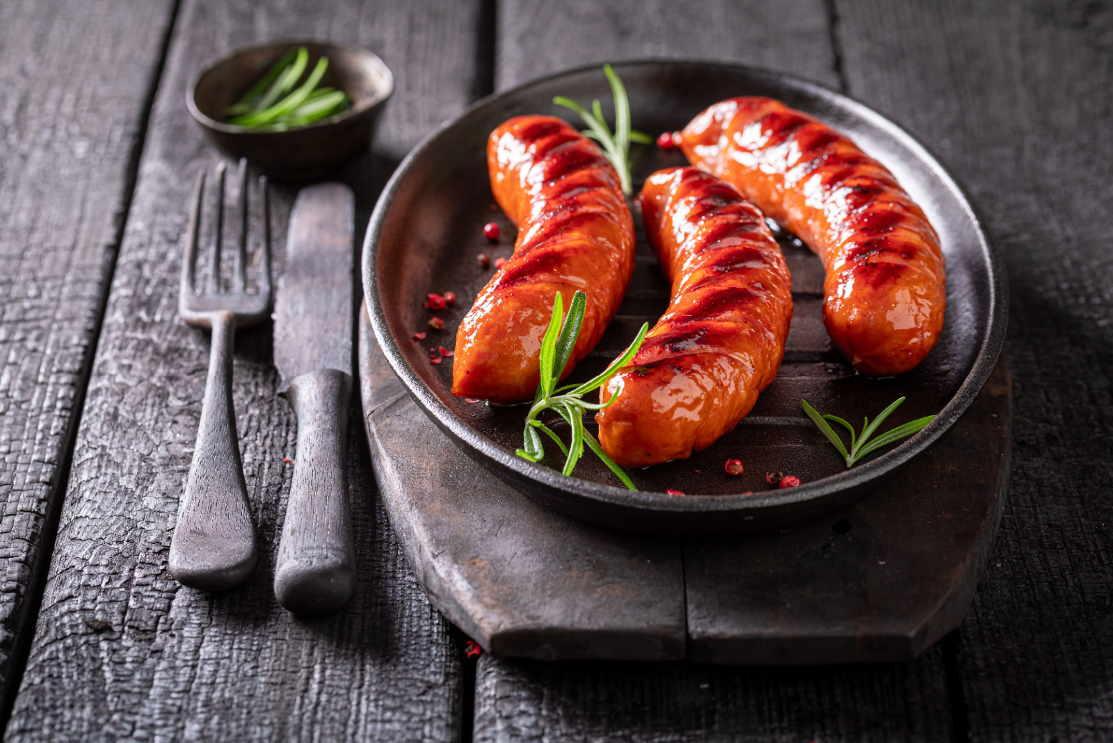 Hot roasted sausage as healthy summer appetizer. Grilled sausage seasoning with rosemary and lime.