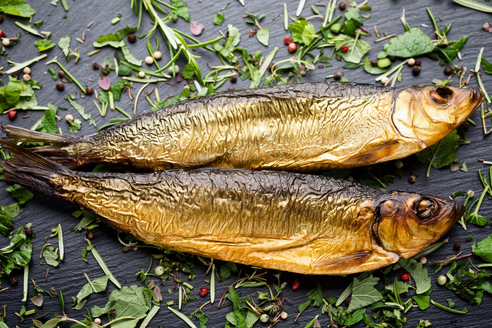 Smoked trout with spices on a stone tray.