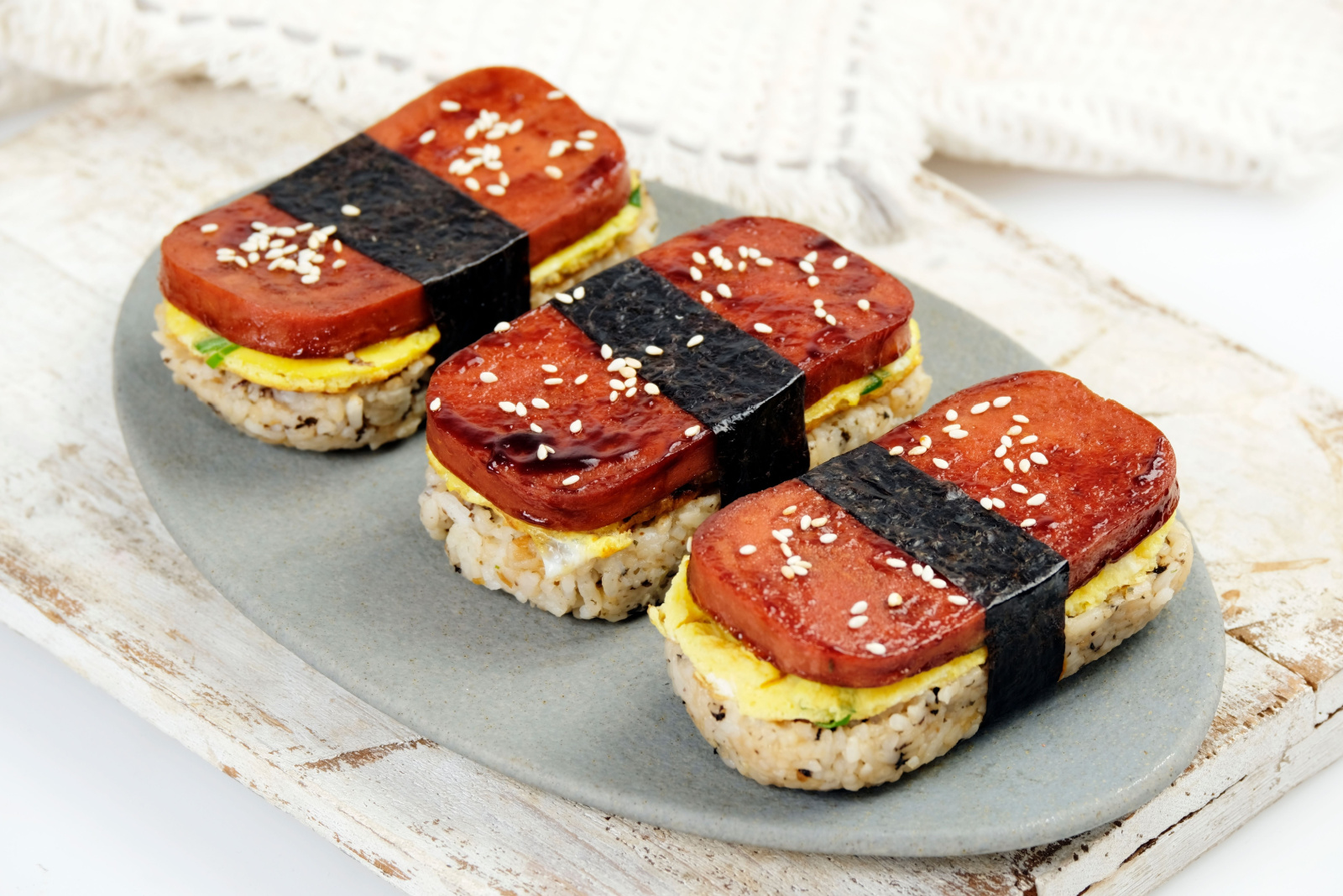 Classic Hawaiian spam musubi, made with grilled spam, seasoned rice, and wrapped with nori seaweed. A delightful fusion snack that combines savory, salty, and umami flavors in each bite.