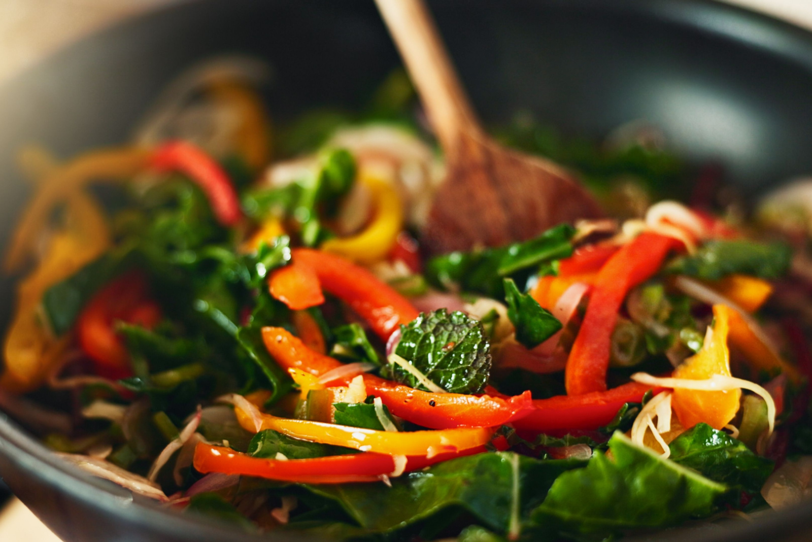 Food, kitchen and spoon in pan for cooking with health, fresh ingredients and wellness with recipe for lunch. Diet, nutrition and vegetable stir fry with stove, heat and meal prep for dinner in home.