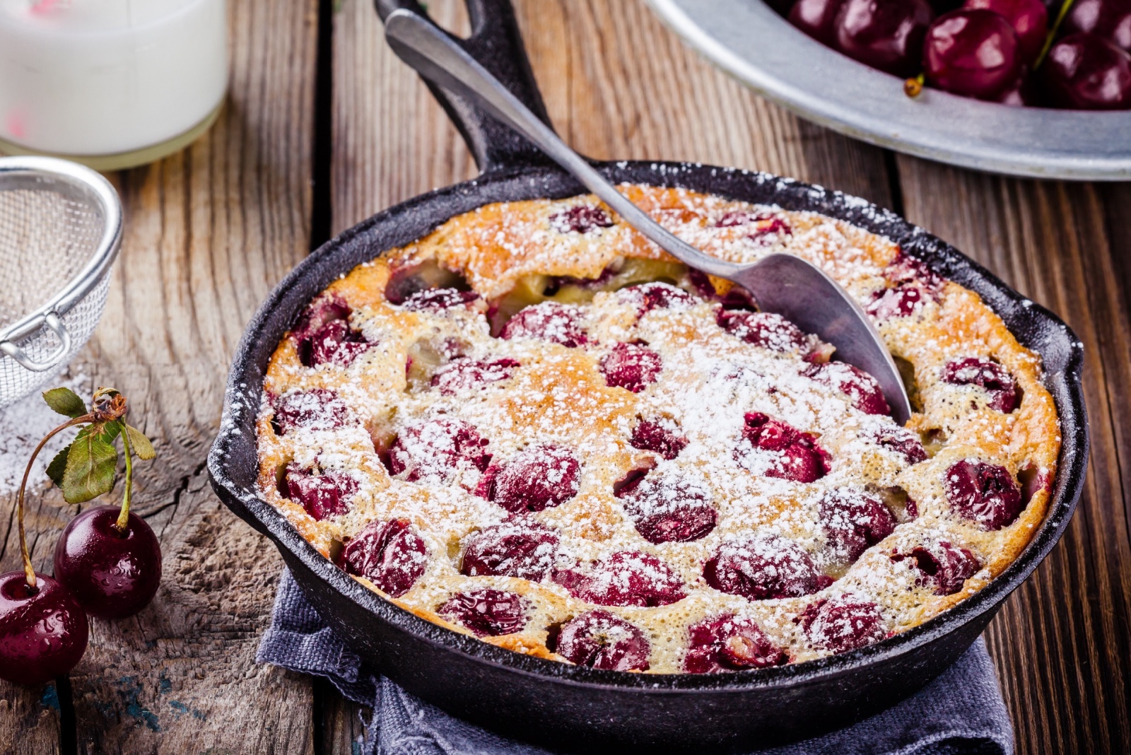 Clafoutis cherry pie on rustic wooden background