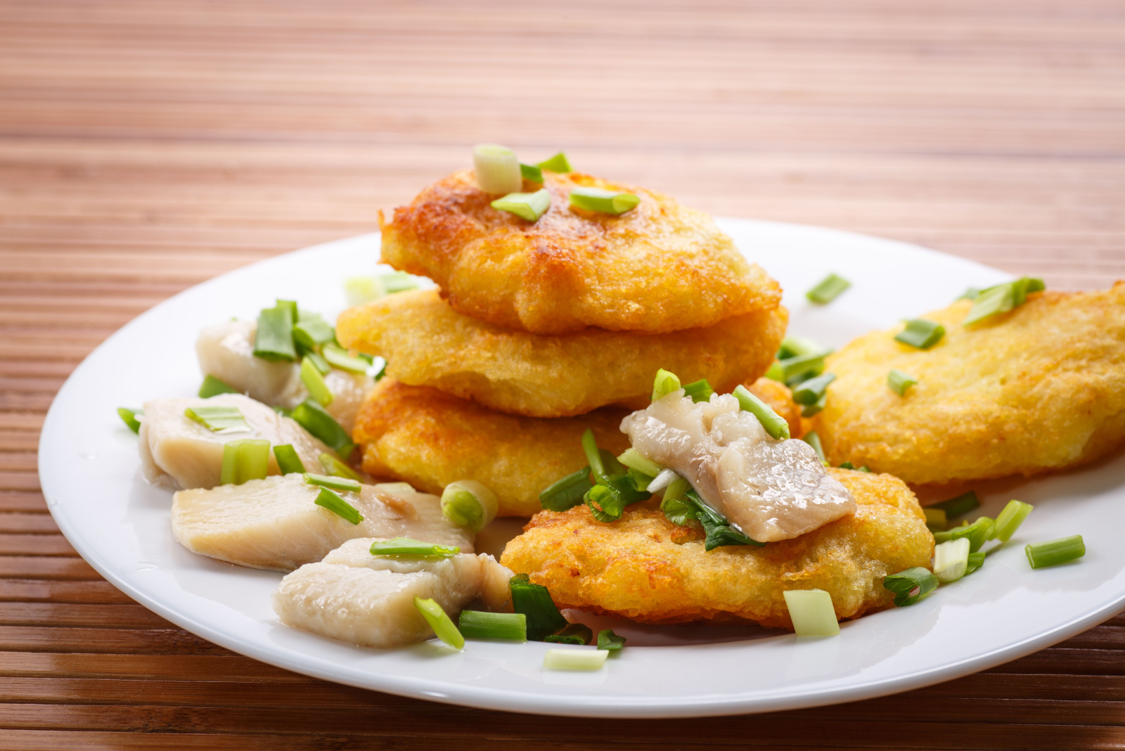 potato pancakes with herring and onion on a plate