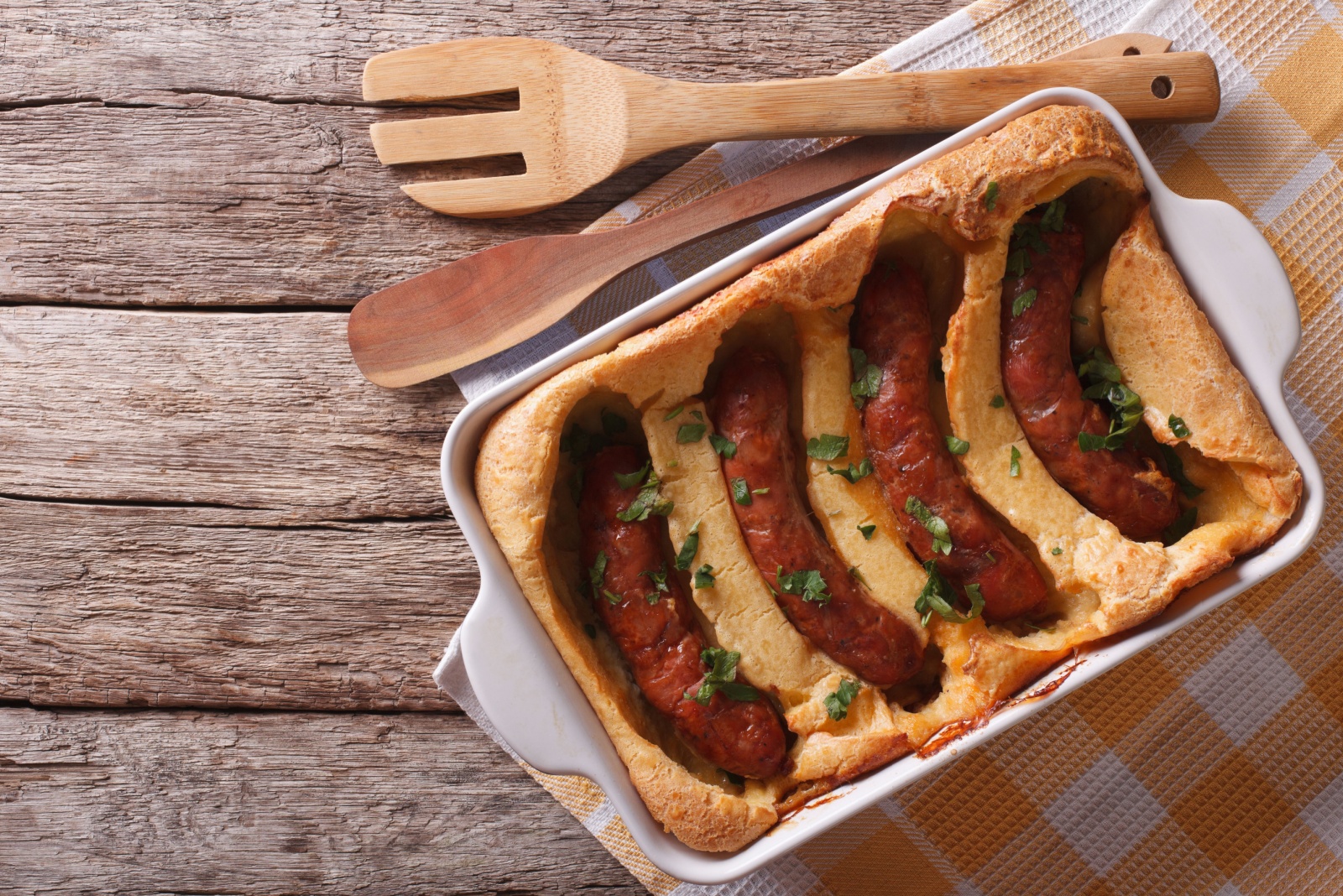 English food: toad in the hole into a baking dish on the table. Horizontal top view