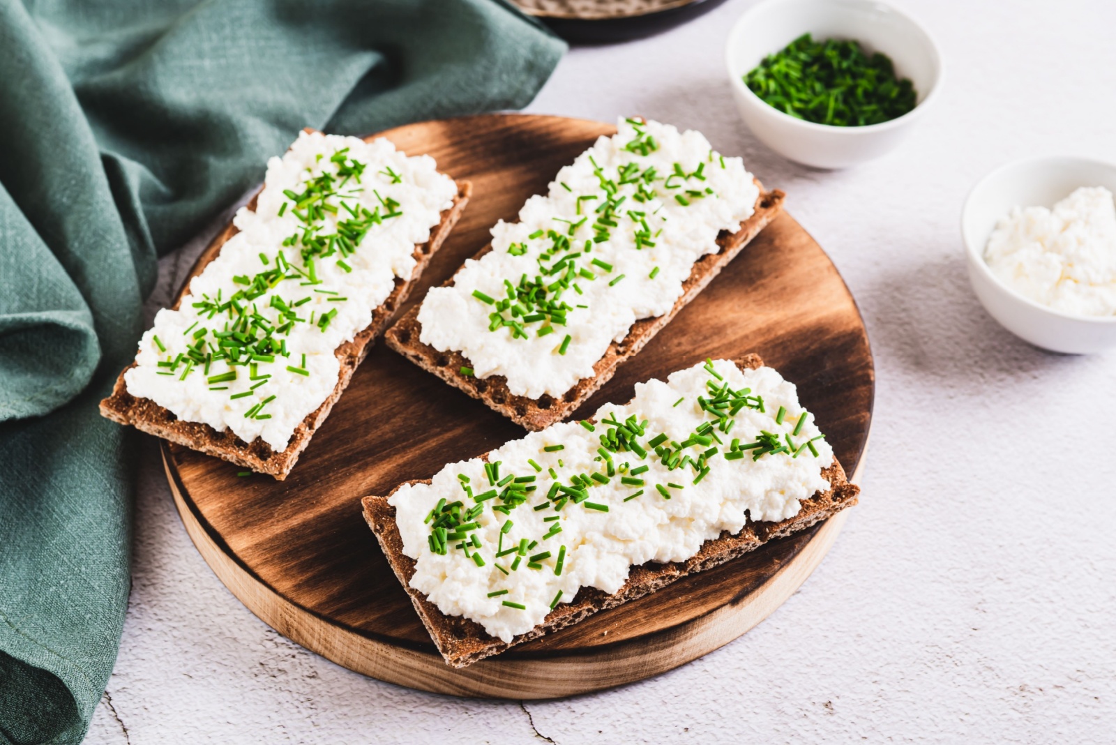 Homemade crispy rye bread with cottage cheese and green onions on a board