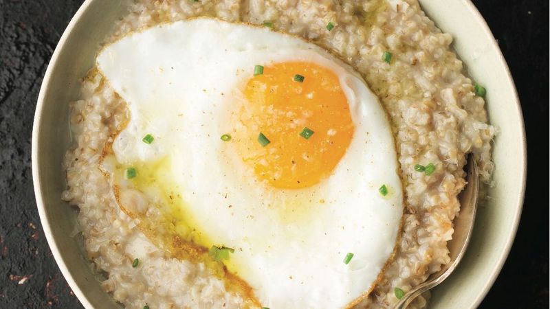 Cracking An Egg Into Porridge Or Broth For Protein