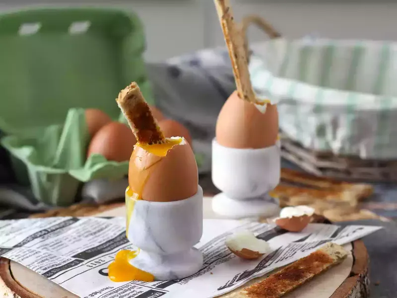 Eating Soft-Boiled Eggs Served In Egg Cups