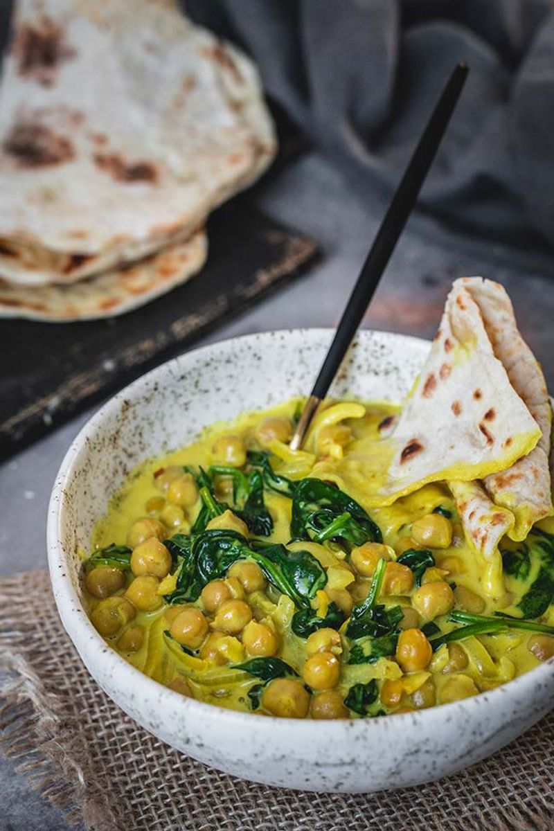 Chickpea And Spinach Coconut Curry Served With Warm Naan