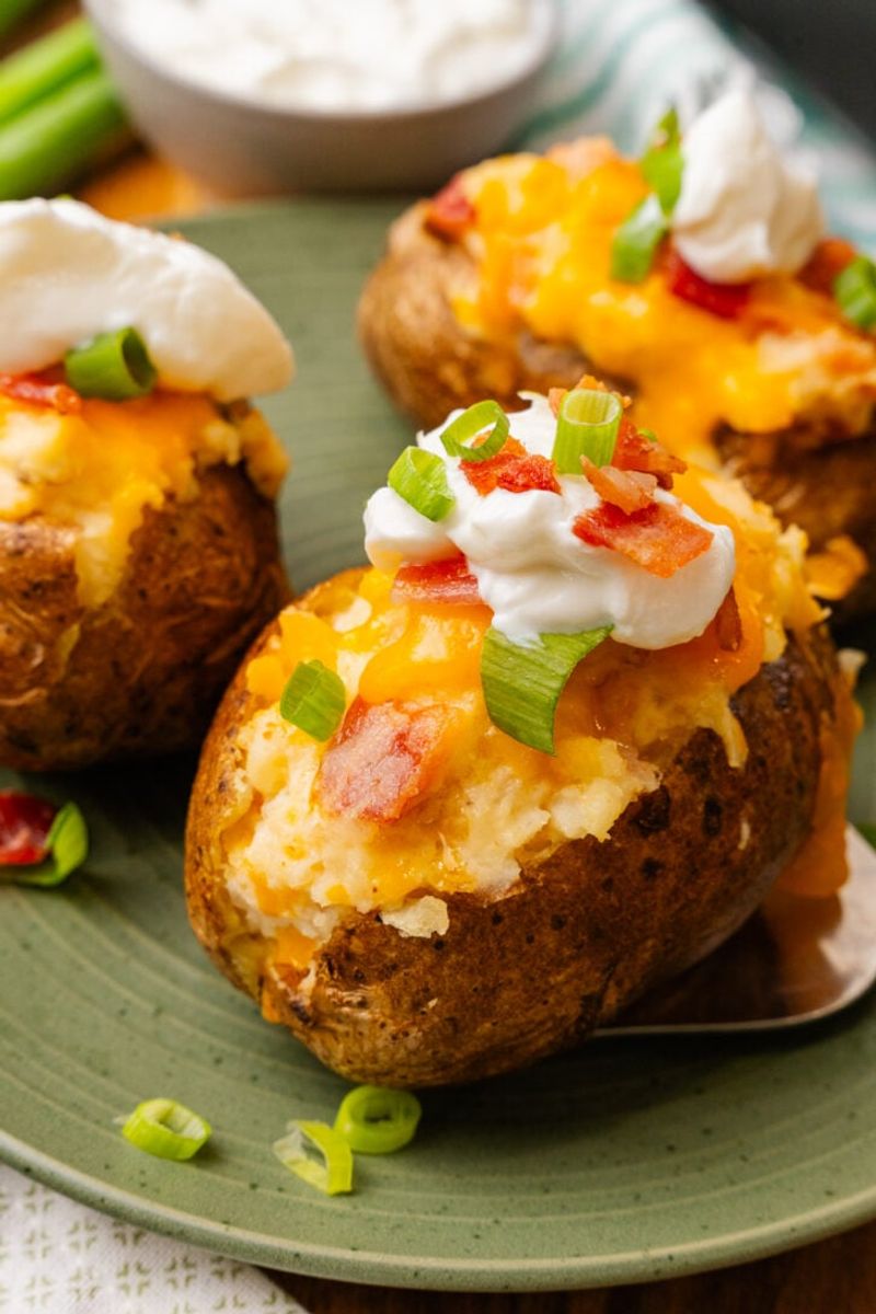 Baked Potato Loaded With Sour Cream, Bacon Bits, And Shredded Cheese