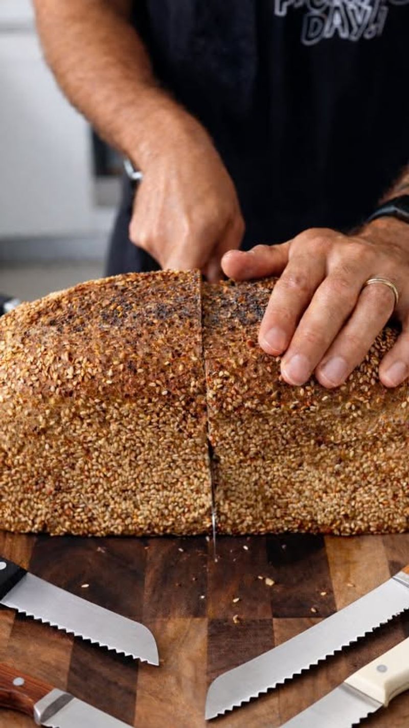 Bread Being Sliced With a Serrated Knife